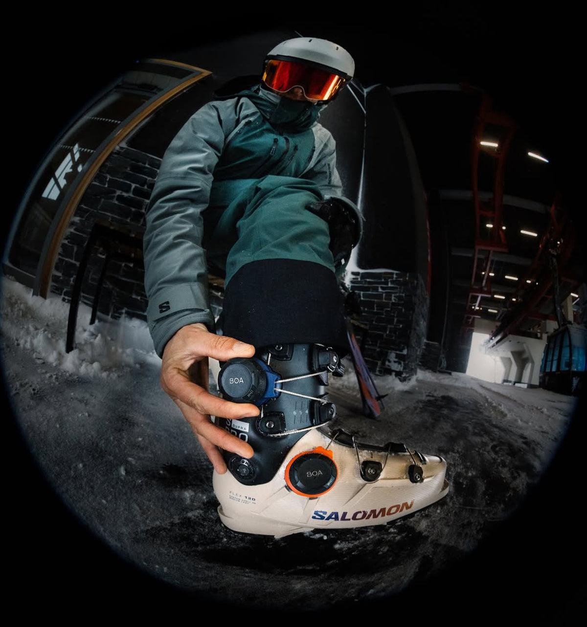 Skier in winter kit adjusting the buckles of a Salomon Shift Pro ski boot