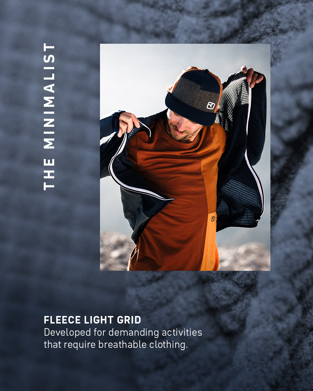 Mann zieht eine dunkle FLEECE LIGHT GRID Jacke über ein rostrotes Merinoshirt