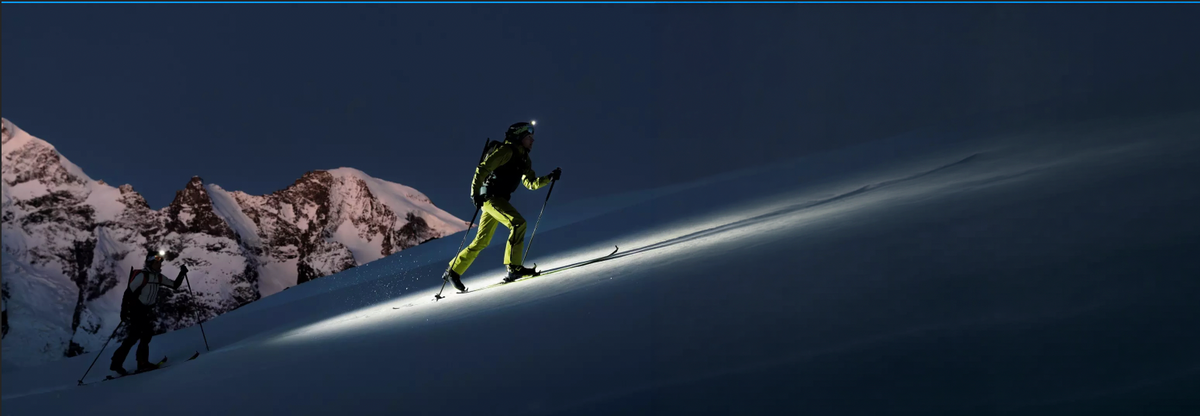 Ski tourer ascending a mountain at dusk