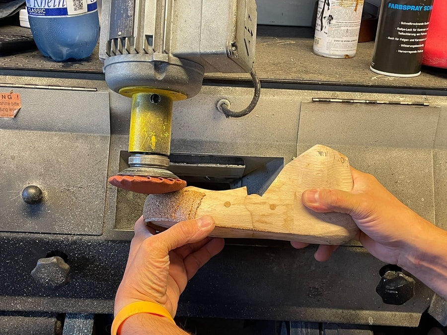 Hölzerner Skischuhleisten mit frisch aufgebautem Kork an der Spitze, in der Hand des Bootfitters.