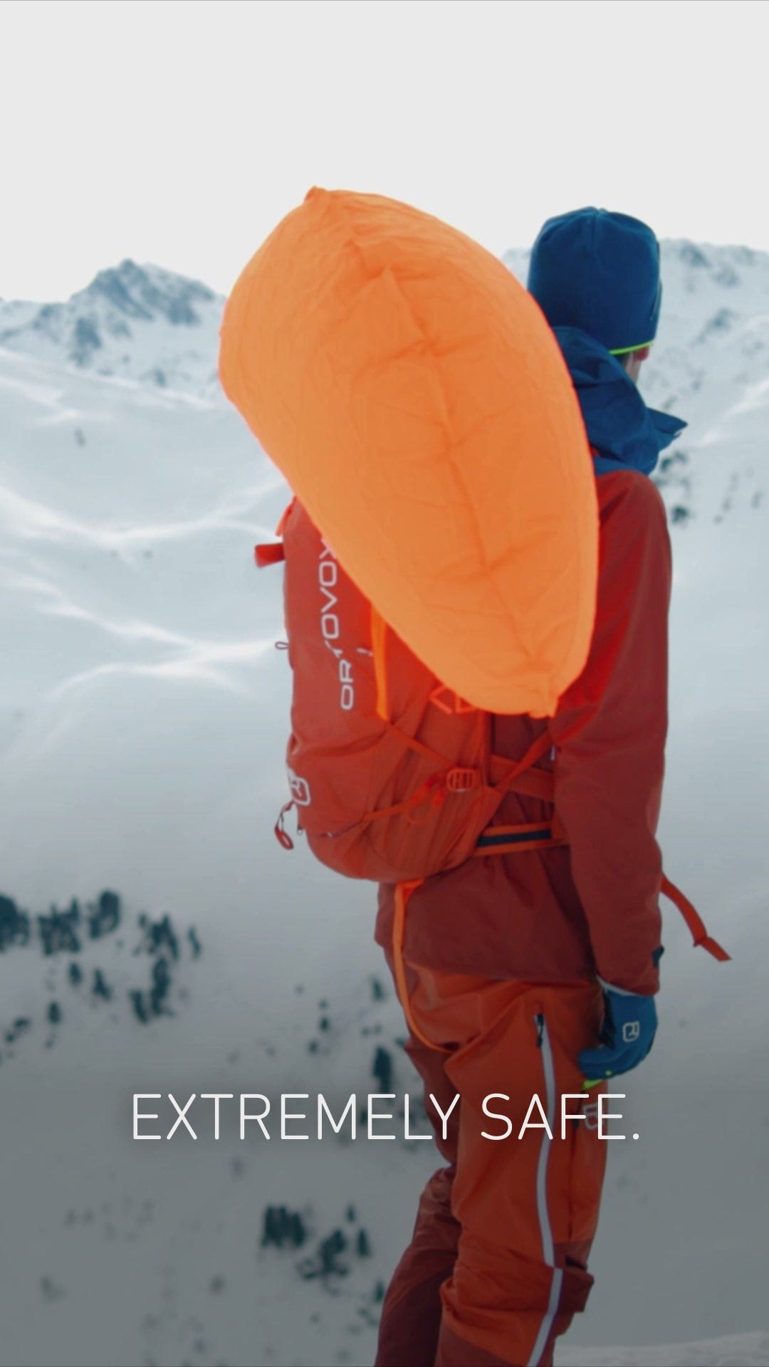 Skitourengeher mit ausgelöstem AVABAG LiTRIC Airbag vor verschneiten Gipfeln