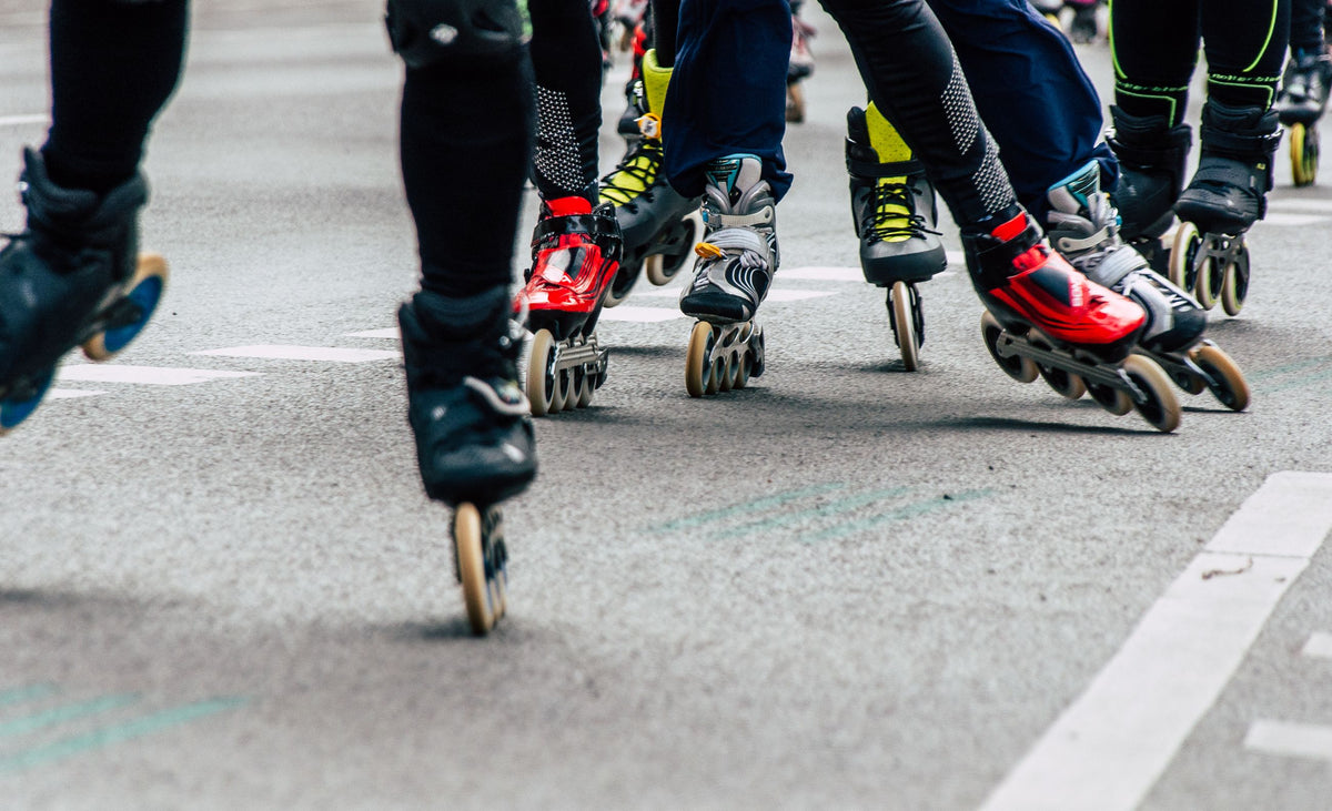 Inline-Skater in Bewegung auf einer Straße, Nahaufnahme der Skates