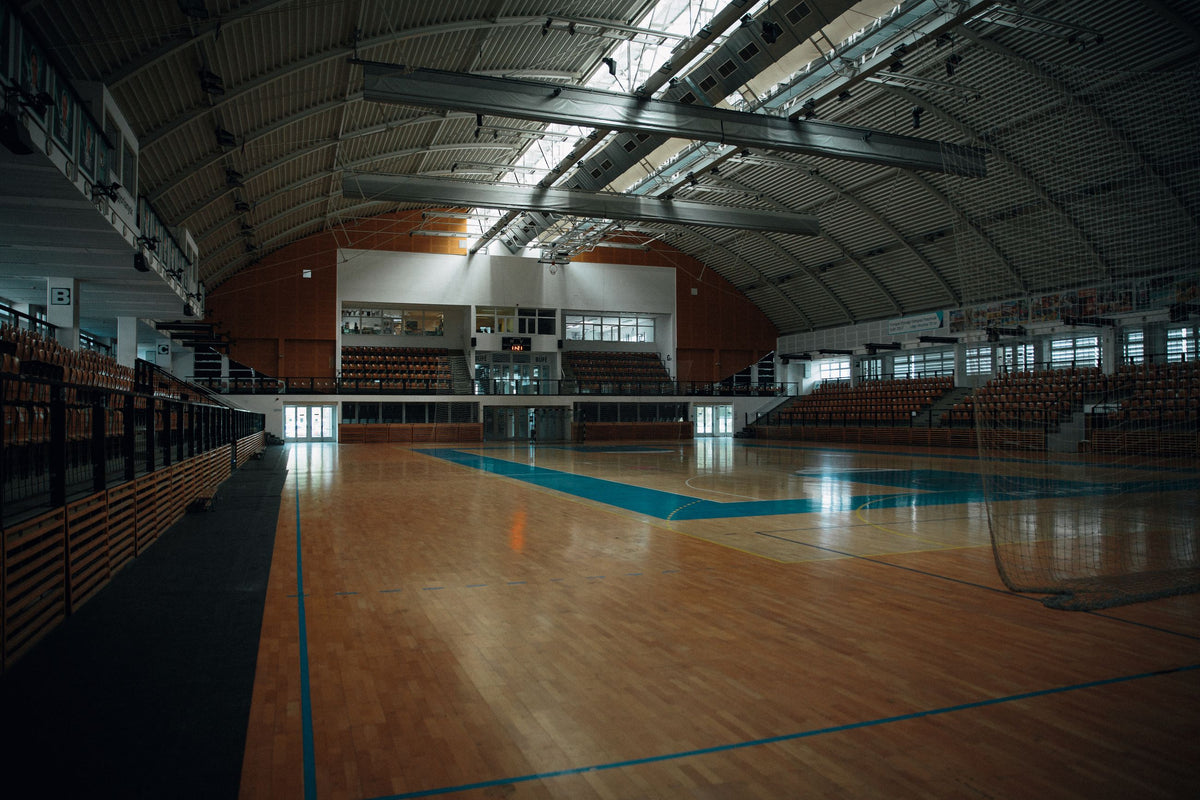 Sporthalle mit markiertem Hallenboden, Tor und Zuschauertribünen