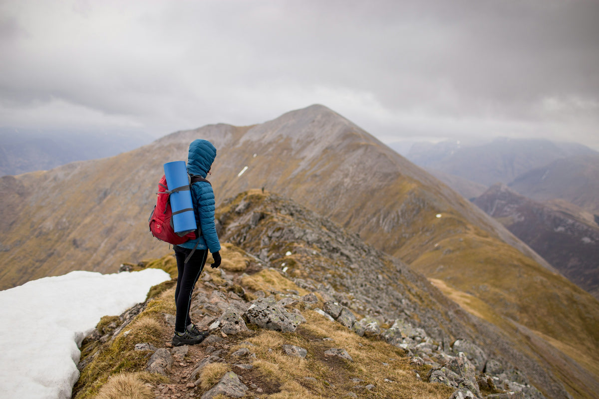Wanderer mit Rucksack auf einem felsigen Berggrat