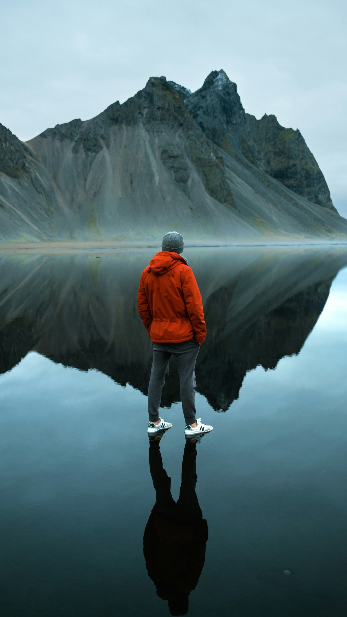 Wanderer in roter Jacke vor einem Bergsee