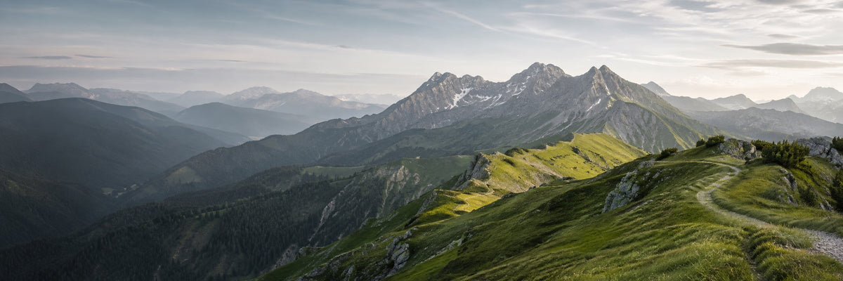 Alpines Bergpanorama mit grünen Hängen und felsigen Gipfeln